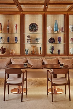 Surrenne Cafe, colourful ornaments and vases line the brightly lit wooden shelves